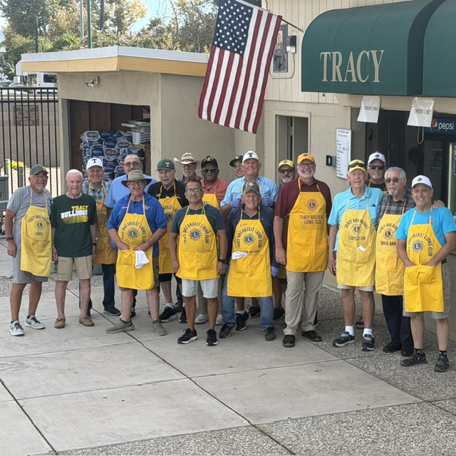 Tracy Breakfast Lions Club volunteers wearing yellow aprons outside the Tracy High snack bar.